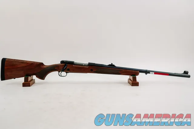 Classic blued bolt-action rifle with wal...