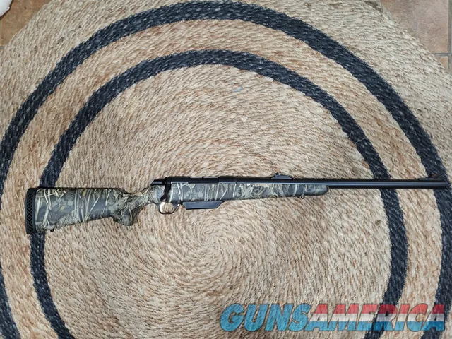 Camo bolt-action hunting rifle with iron...